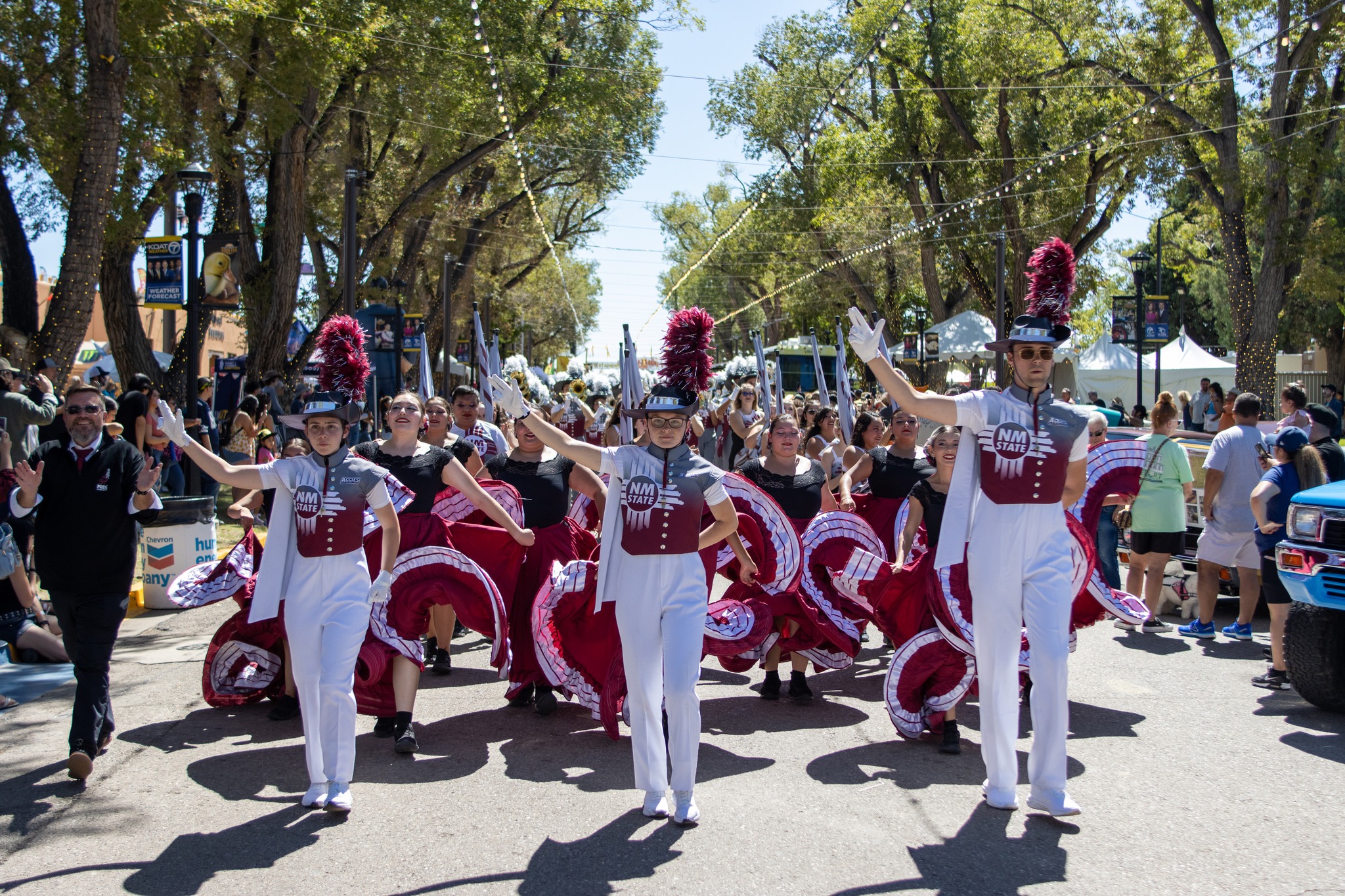 Members of the Pride of New Mexico including the three drum majors and ballet folklorico members march down the main street at the New Mexico State Fair on September 16, 2023. 
