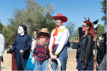 Individuals stand in their Halloween costumes during the Costume Contest at the 2023 Employee Appretiation Picnic. 