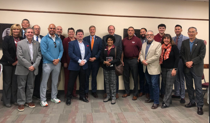 Members of NMSU leadership, Mayor Tim Keller, and the mayor's team stand together for a group photo. 