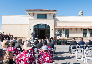 Individuals listen to Dean Rolando Flores Galzara at the ribbon cutting of the new College of ACES buildings. 