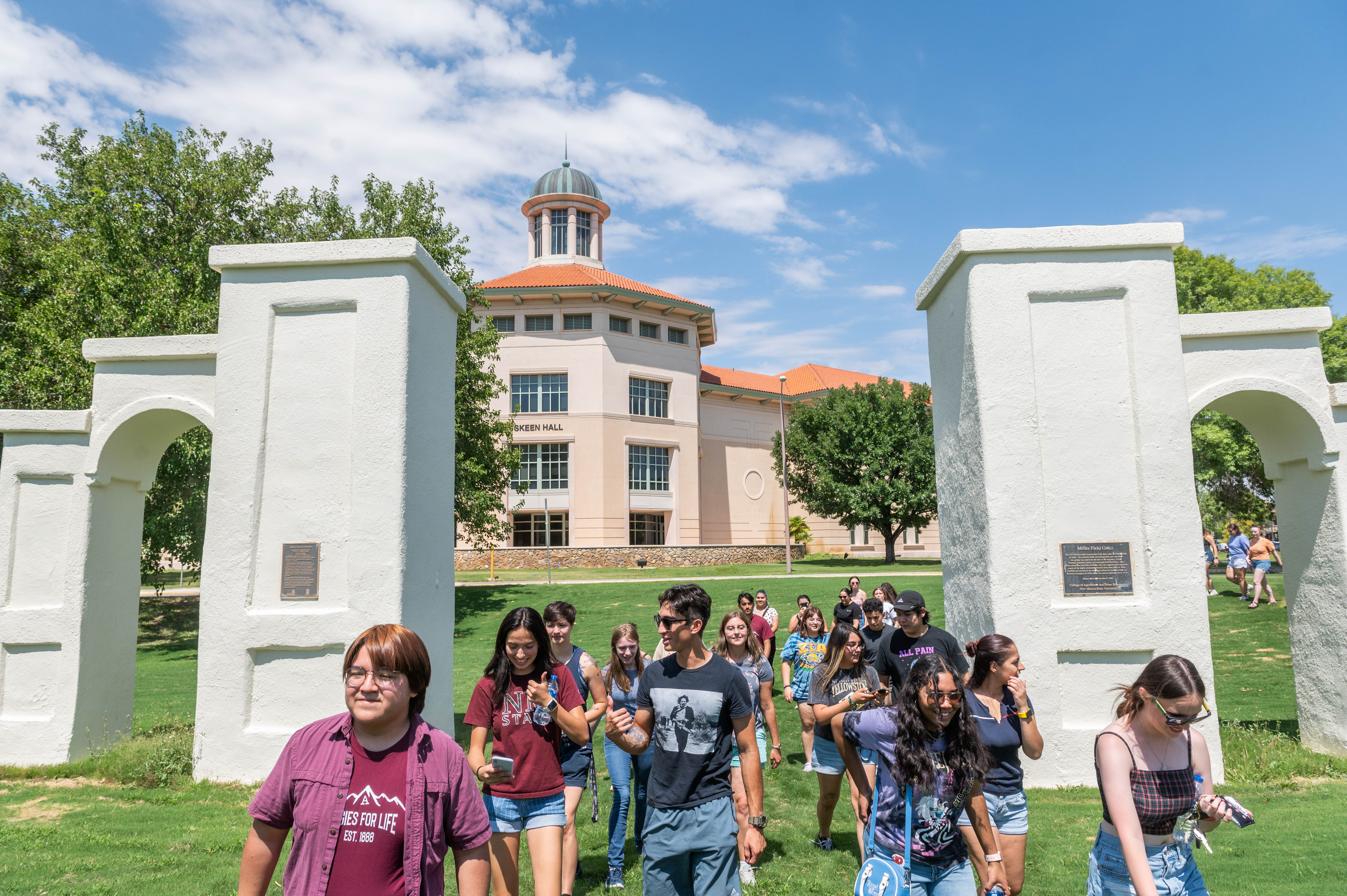 Students walking in a group through the original arches on campus during the freshman walk. 