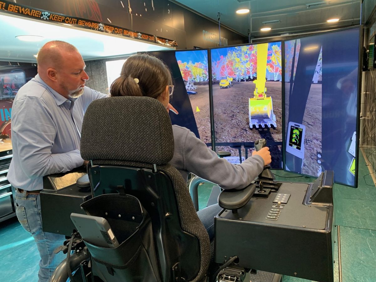 Student learning to use an excavator simulator at the Energy Career Fair and Symposium.